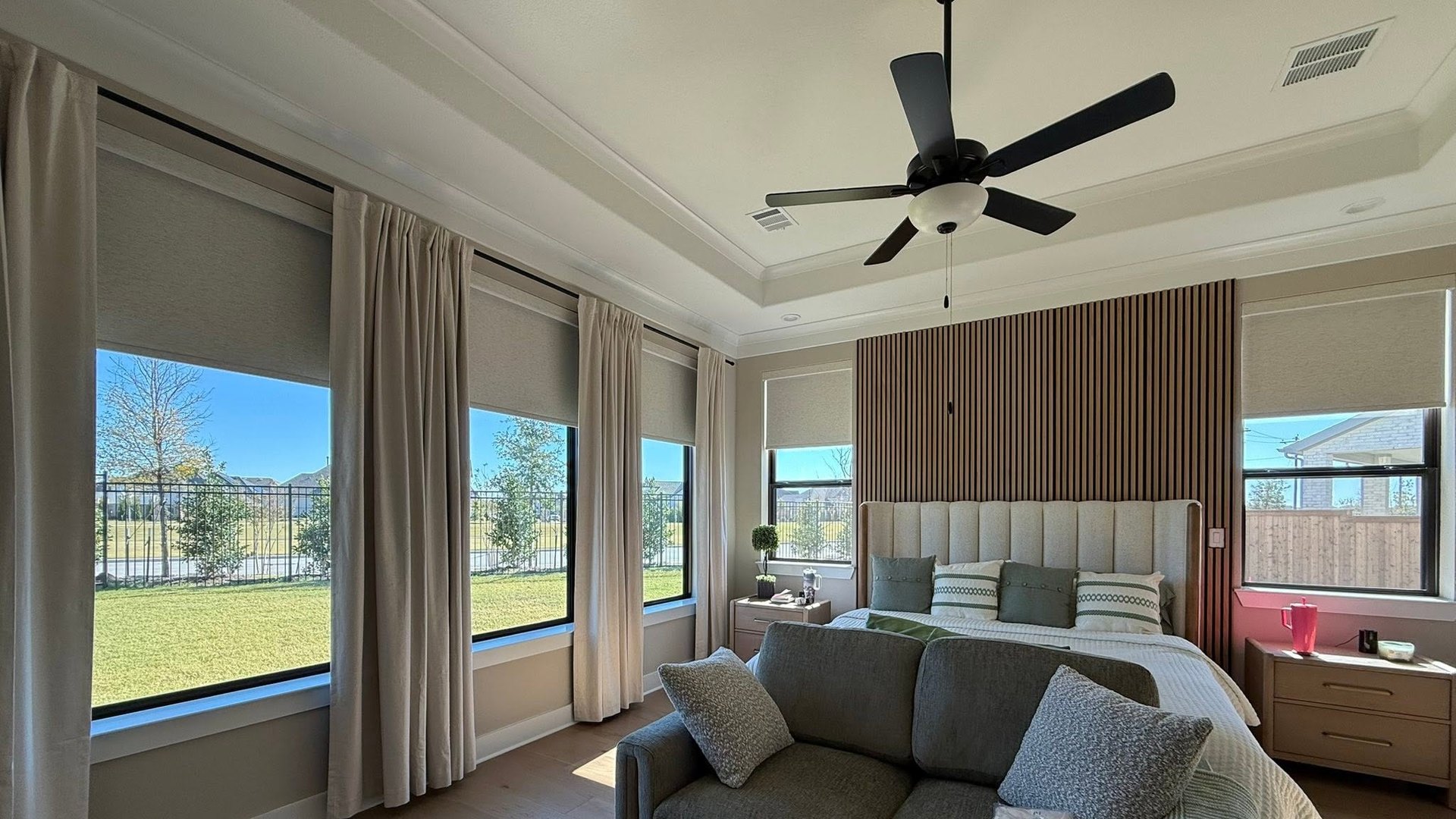 A sunlit bedroom with spotless black framed windows